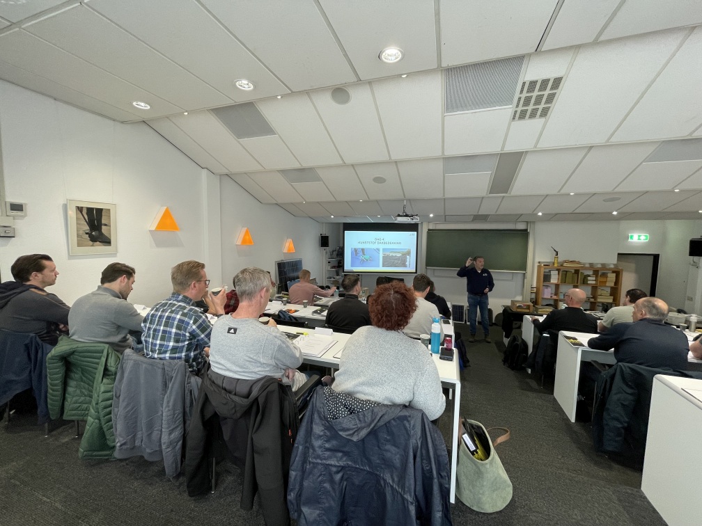 De collegezaal van BDA Dak- en Gevelopledingen met deelnemers en een docent